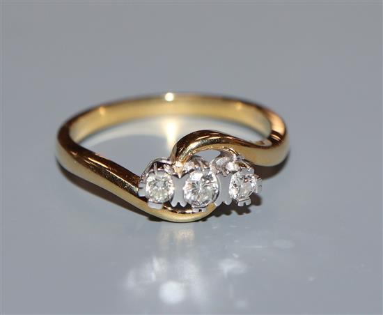 A modern 18ct gold and three stone diamond crossover ring, size O.